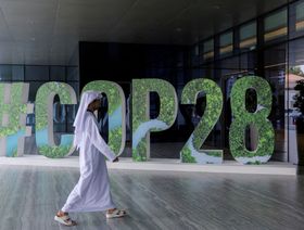 أحد الأشخاص يمر أمام لافتة خاصة بقمة المناخ "كوب 28" الإمارات (COP28) وُضعت خلال ورشة عمل للقيادة الفكرية على مستوى المسؤولين التنفيذيين للتركيز على العمل المناخي، في العاصمة الإماراتية أبوظبي، يوم 1 أكتوبر 2023 - المصدر: بلومبرغ