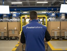 موظف ينقل الصناديق على شاحنة نقالة في مركز فرز "البريد الإيطالي" في ميلانو، إيطاليا - بلومبرغ