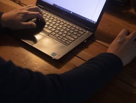 يدا رجل على جهاز حاسوب يعمل من المنزل - المصدر: بلومبرغ