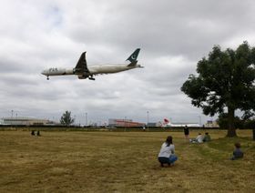 أشخاص  يتابعون حركة طائرة ركاب، تديرها شركة الخطوط الجوية الدولية الباكستانية، وهي بصدد الهبوط بمطار هيثرو في لندن، المملكة المتحدة - المصدر: بلومبرغ