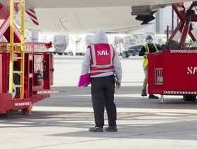 عاملان ومعدات تابعة لشركة "سال السعودية للخدمات اللوجستية" أثناء مناولة إحدى الطائرات - المصدر: بلومبرغ