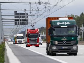 تسير شاحنة البضائع الإلكترونية "سكانيا AB R450" التي تعمل بخطوط طاقة كهربائية علوية جنبًا إلى جنب مع شاحنات أخرى غير كهربائية على الطريق السريع A5 بين فرانكفورت ودارمشتات، ألمانيا. - المصدر: بلومبرغ