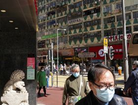 أشخاص يرتدون أقنعة للوجه لمنع انتشار فيروس كورونا في أحد شوارع هونج كونج.  2 ديسمبر 2021 - المصدر: رويترز