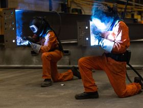 عاملان يقومان بلحام أجزاء من العوارض الفولاذية المصنعة - المصدر: بلومبرغ