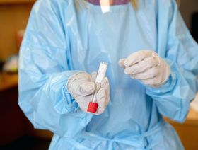 ممرضة تحمل عينة من اختبار كوفيد في مركز طبي - المصدر: بلومبرغ