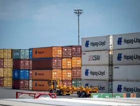 شاحنة تمر بجانب حاويات شحن في ميناء مونتريال، كندا - بلومبرغ