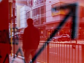 انعكاس أحد المشاة في لافتة في هونغ كونغ، الصين - المصدر: بلومبرغ