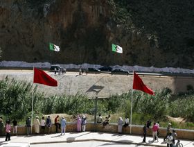 أشخاص يقفون على جانبي نقطة حدودية بين المغرب والجزائر شمال شرق المغرب - المصدر: رويترز