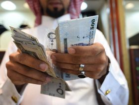 تاجر يعد أوراقاً نقدية من فئة 500 ريال سعودي في محل للمجوهرات في سوق طيبة بالعاصمة الرياض، السعودية - المصدر: غيتي إيمجز