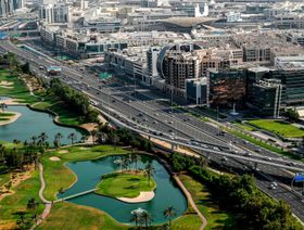 صورة جوية تظهر جانباً من شبكة المواصلات الحديثة تخترق منتجعاً شاسعاً للغولف ومباني تجارية في مدينة دبي. الإمارات العربية المتحدة - المصدر: بلومبرغ