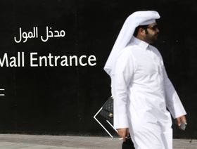 رجل يعبر من أمام لافتة ترشد إلى مدخل "دبي مول" الذي تديره شركة "إعمار مولز"، في دبي. الإمارات العربية المتحدة - المصدر: بلومبرغ