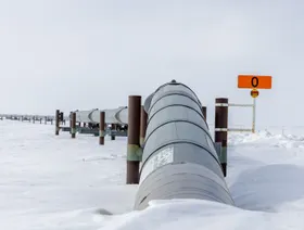 خط أنابيب يمتد عبر سهل جليدي واسع مع دعامات ترفع الأنابيب عن الأرض وعلامة برتقالية تحمل الرقم "0" - Getty Images