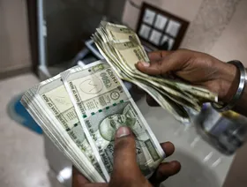 شخص يعد أوراق نقد هندية من فئة 500 روبية في مكتب صرافة في نيودلهي - بلومبرغ