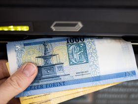 أوراق نقدية من الفورينت المجري تُسحب من ماكينة صراف آلي في بودابست، المجر - المصدر: بلومبرغ