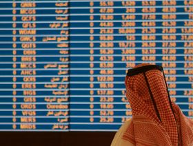 مستثمر يراقب حركة الأسهم على شاشة عرض في بورصة قطر - المصدر: رويترز