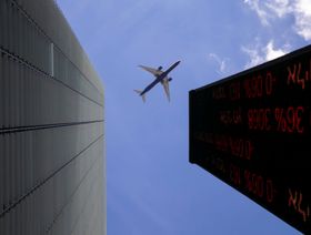 طائرة تحلق فوق منطقة الأعمال في تل أبيب وتظهر في الصورة لوحة رقمية تعرض أسعار الأسهم في بورصة تل أبيب (صورة أرشيفية) - المصدر: بلومبرغ