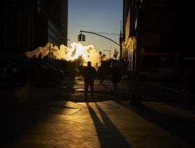 بخار يتصاعد أثناء عبور مشاة شارعا بالقرب من بورصة نيويورك ، الولايات المتحدة - المصدر: بلومبرغ