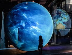 طفلة تتفقد نموذج لكوكب الأرض في متحف العلوم الطبيعية في برشلونة، إسبانيا - المصدر: بلومبرغ