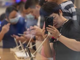 زائر يجرب هاتفاً ذكياً داخل متجر هواوي الرئيسي في شنغهاي، الصين - المصدر: بلومبرغ
