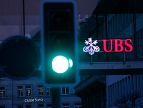 شعار "يو بي إس" على الواجهة الزجاجية لمبنى المكاتب التابع له المقابل لأحد فروع "كريدي سويس" في مدينة زيورخ، سويسرا  - المصدر: بلومبرغ