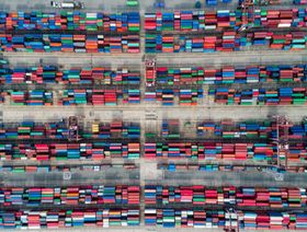 حاويات بحرية مكدسة في ميناء بحري - المصدر: بلومبرغ