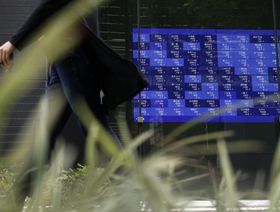شخص يعبر من أمام لوحة إلكترونية تعرض أسعار الأسهم خارج مبنى في طوكيو، اليابان، يوم الخميس 1 يونيو 2023. - المصدر: بلومبرغ