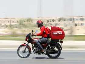عامل في شركة "أرامكس" يقود دراجته النارية على الطريق السريع في القاهرة - المصدر: رويترز