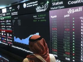 رجل ينظر إلى حركة الأسهم على لوحة إلكترونية داخل سوق الأسهم السعودية، تداول، في الرياض، المملكة العربية السعودية (صورة أرشيفية) - Simon Dawson/Bloomberg
