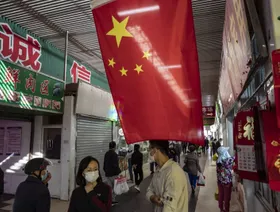 علم الصين يتدلى أمام متجر في سوق للأطعمة الطازجة في شنغهاي، الصين - المصدر: بلومبرغ