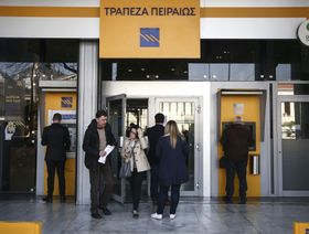 عملاء يستخدمون ماكينة الصراف الآلي بفرع لمصرف "بيريوس بنك" في أثينا - المصدر: بلومبرغ