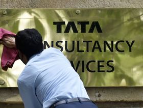 عامل ينظف لافتة خارج المقر الرئيسي لشركة "تاتا كونولتانسي سيرفيسز" بمومباي في الهند - المصدر: بلومبرغ