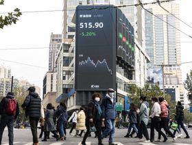 مشاه يمرون أمام شاشة عامة تعرض أداء الأسهم في شنغهاي، الصين. - المصدر: بلومبرغ