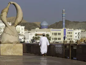 مواطن عُماني يسير على كورنيش مطرح الذي تصطف على جانبيه منازل تجار القرن التاسع عشر بمدينة مسقط القديمة، عمان - المصدر: بلومبرغ