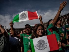 مشجعون يرفعون أعلام المكسيك بعد مبارة لكرة القدم بلادهم في بطولة كأس العالم 2018 - المصدر: بلومبرغ