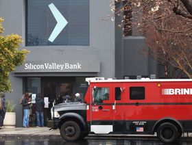 سيارة تمر أمام مصرف "سليكون فالي" وفي الصورة مجموعة من العملاء عند باب البنك - المصدر: بلومبرغ
