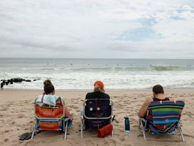 زوار يجلسون على شاطئ جيرسي، الولايات المتحدة  - المصدر: بلومبرغ