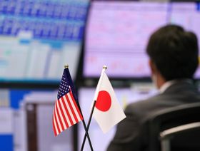 العلمان الأميركي والياباني داخل قاعة التداول في شركة الوساطة المالية "غايتام.كوم" (Gaitame.Com Co.) في طوكيو، بتاريخ 21 أكتوبر 2022 - المصدر: بلومبرغ