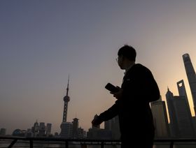 أحد المشاة يمر أمام مباني منطقة لوجياتسوي المالية في بودونغ، شنغهاي، الصين - المصدر: بلومبرغ