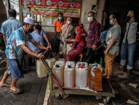 الناس يصطفون في طابور لشراء زيت الطهي المقدم من الحكومة المحلية في سورابايا. - المصدر: غيتي إيمجز