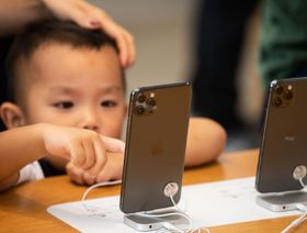 طفل يحاول استخدام هاتف ذكي من "أبل" في متجر "أبل" في هونغ كونغ، الصين - المصدر: بلومبرغ