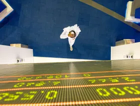 مستثمر يمشي أمام لوحة مؤشر أسعار الأسهم في سوق دبي المالي، الإمارات العربية المتحدة - بلومبرغ