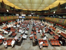 متداولون داخل بورصة الكويت يتابعون حركة الأسهم - المصدر: بلومبرغ