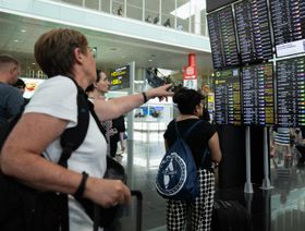 ركاب ينظرون إلى شاشة تعرض الرحلات الجوية المتأخرة في مطار برشلونة بسبب العطل التقني العالمي في 19 يوليو 2024 في برشلونة، إسبانيا - Getty Images