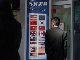 عميل خارج شركة صرافة "نينجا" لتغيير العملات تديرها "إنتر بنك" بمنطقة شينجوكو في طوكيو في اليابان - المصدر: بلومبرغ