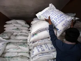 شخص يرتب أجولة من السكر المكرر - بلومبرغ