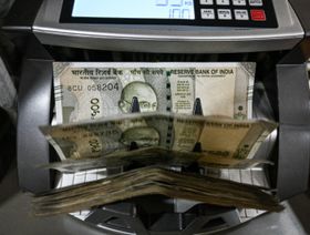 أوراق نقدية من الروبية الهندية داخل آلة لعد النقود - بلومبرغ