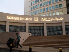 رجل يدفع عربة أمام مقر مصرف لبنان في بيروت، لبنان - بلومبرغ