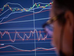متداول ينظر إلى شاشة تعرض حركة الأسهم - المصدر: بلومبرغ