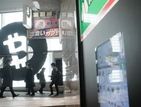 مشاة يمرون أمام متجر "ساكورا إكستشينج بتكوين" في حي شيبويا، طوكيو، اليابان - المصدر: بلومبرغ