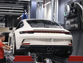 عامل يثبت اسم الشركة على سيارة بورشه "911 ST" في مصنع بورشه في شتوتغارت، ألمانيا - بلومبرغ